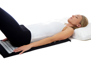 Acupressure mat. Woman lying down on the Chi-mat acupressure mat.